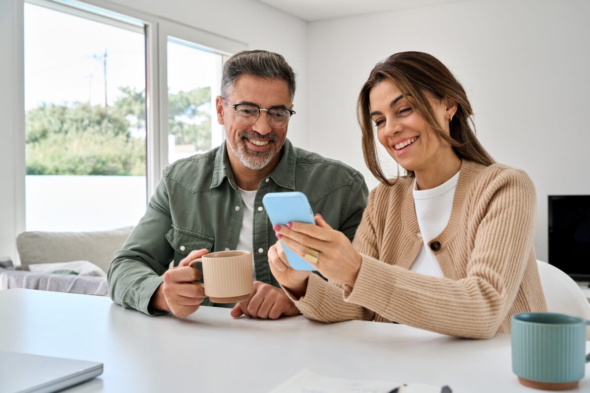 Couple reviewing pension investments on a smartphone, representing the most bought pension ETFs in 2025.